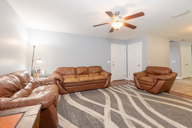 living room featuring a ceiling fan and visible vents
