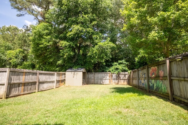 view of yard featuring a storage shed, an outdoor structure, and a fenced backyard