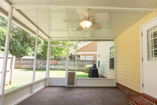 unfurnished sunroom featuring a ceiling fan and plenty of natural light