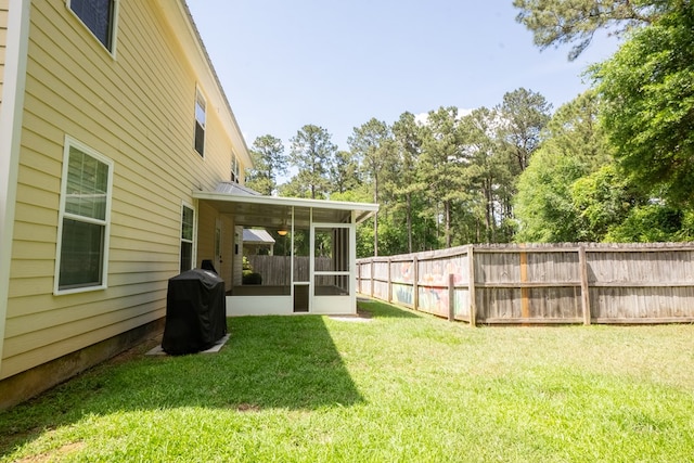 view of yard with fence and a sunroom