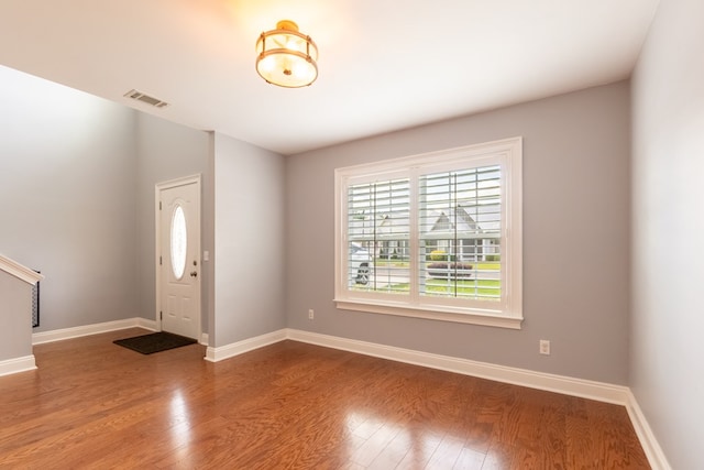 foyer featuring baseboards, visible vents, wood finished floors, and a wealth of natural light
