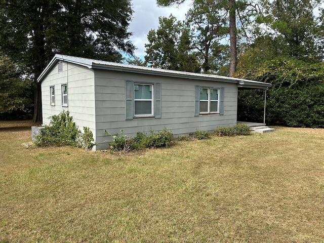 view of side of home with a yard