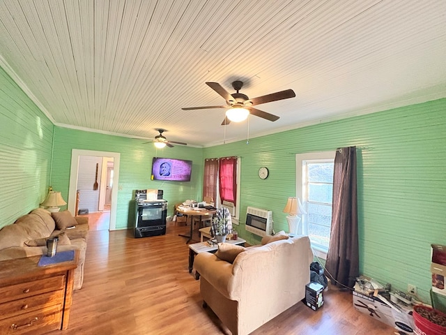 living room with ornamental molding, heating unit, and wood finished floors