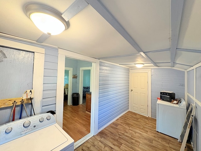 washroom featuring laundry area, light wood-style flooring, wooden walls, and washer / clothes dryer