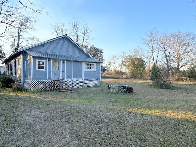 exterior space featuring a front yard, metal roof, and entry steps