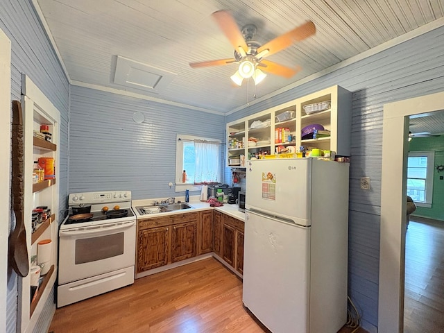 kitchen featuring brown cabinets, light wood-style flooring, glass insert cabinets, a sink, and white appliances