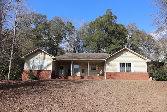 ranch-style house featuring a porch and brick siding