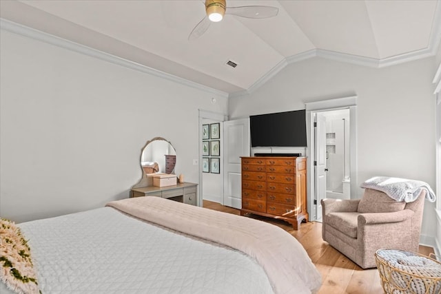 bedroom featuring ceiling fan, visible vents, vaulted ceiling, wood finished floors, and ornamental molding