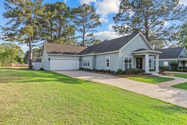 view of front facade with fence, an attached garage, driveway, and a front lawn