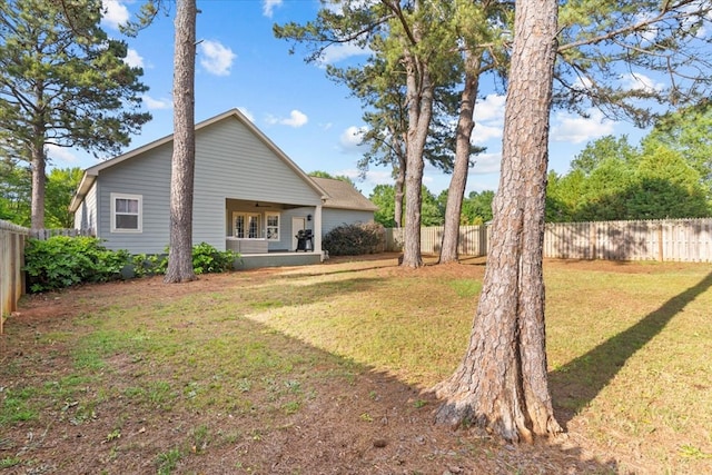 back of house featuring a fenced backyard and a yard