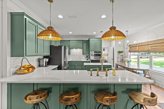 kitchen featuring a sink, light countertops, green cabinets, and appliances with stainless steel finishes