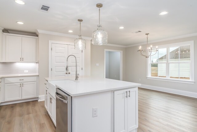 kitchen with pendant lighting, stainless steel appliances, white cabinetry, and an island with sink