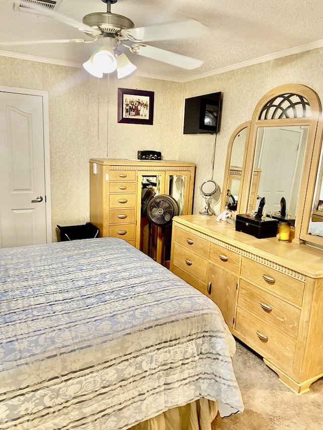 carpeted bedroom with a textured ceiling, ceiling fan, and crown molding