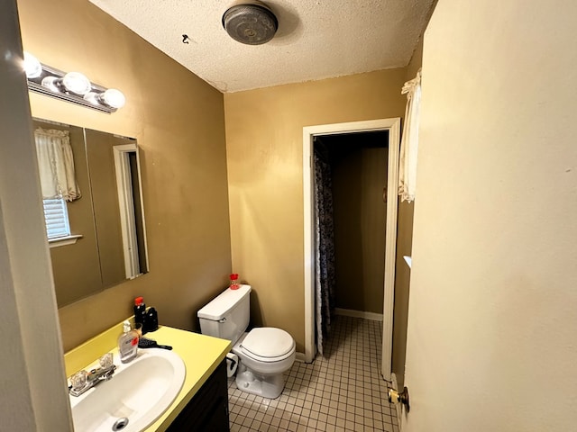 bathroom featuring toilet, a textured ceiling, vanity, and tile patterned floors