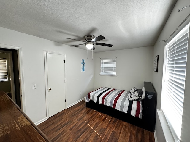 bedroom featuring a textured ceiling, ceiling fan, and dark wood-type flooring