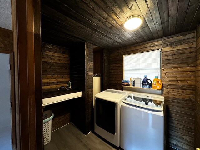 laundry area featuring dark hardwood / wood-style flooring, wood walls, washer and clothes dryer, and wooden ceiling