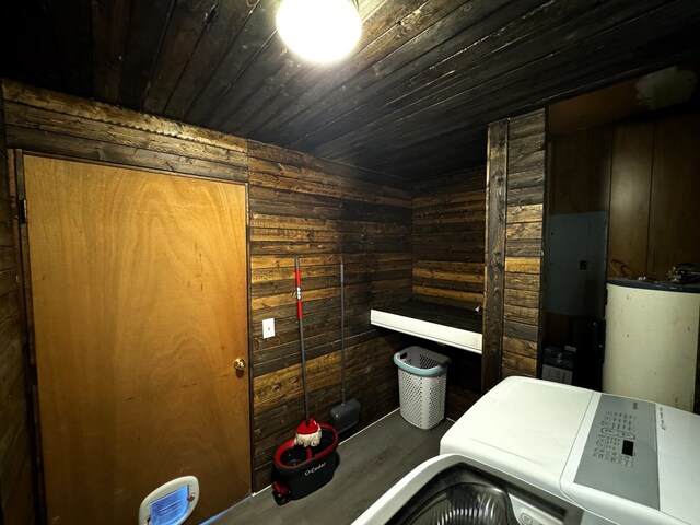 clothes washing area featuring wood ceiling, wooden walls, and water heater