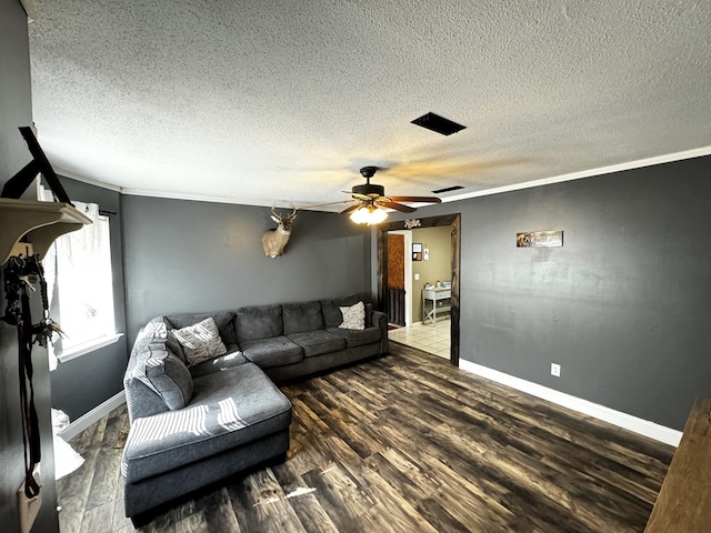 living room with a textured ceiling, dark hardwood / wood-style floors, and crown molding