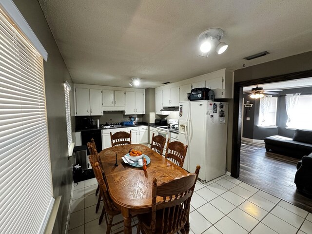 tiled dining space with sink and a textured ceiling