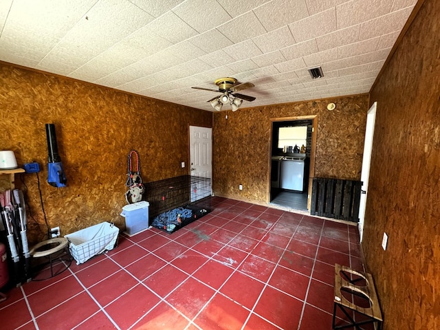 unfurnished living room featuring ceiling fan and dark tile patterned floors