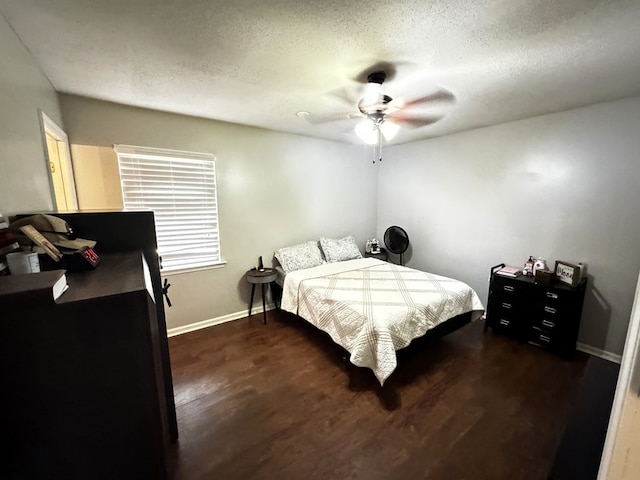 bedroom featuring ceiling fan, dark hardwood / wood-style floors, and a textured ceiling