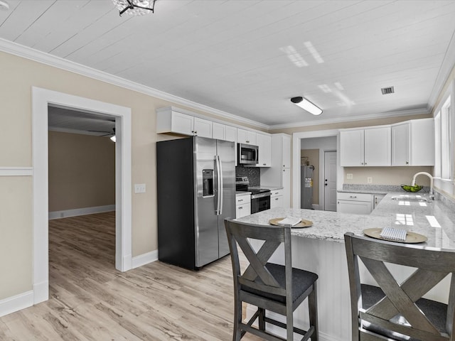 203 E Mckinnon St, New Brockton, AL 36351 - kitchen featuring stainless steel appliances, a peninsula, crown molding, white cabinets, and light stone countertops