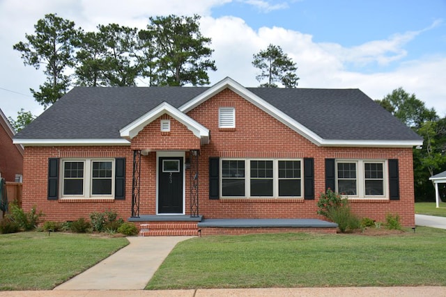 203 E Mckinnon St, New Brockton, AL 36351 - view of front of house featuring brick siding, a front yard, and roof with shingles
