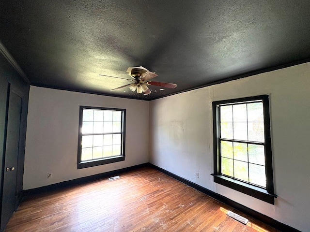 176 Camilla Ave, Ozark, AL 36345 - empty room featuring a textured ceiling, wood finished floors, a ceiling fan, baseboards, and crown molding