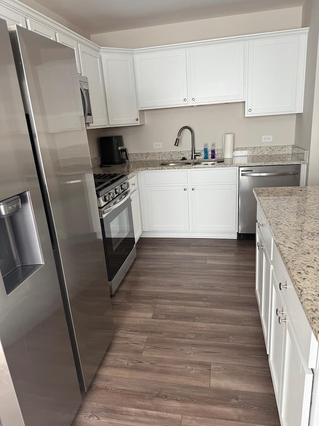 kitchen featuring stainless steel appliances, white cabinetry, sink, and dark wood-type flooring