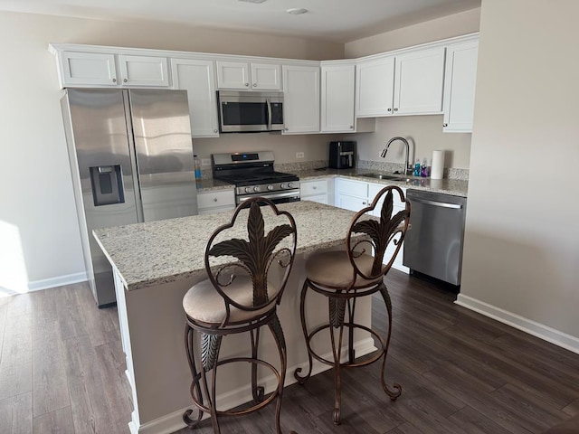 kitchen featuring a kitchen island, white cabinets, appliances with stainless steel finishes, and sink