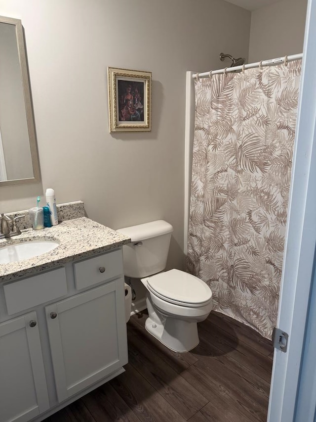 bathroom with toilet, vanity, and hardwood / wood-style flooring