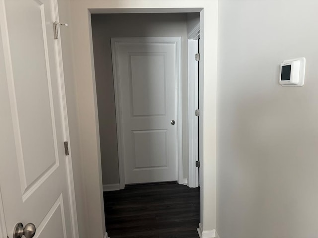 corridor with dark hardwood / wood-style flooring