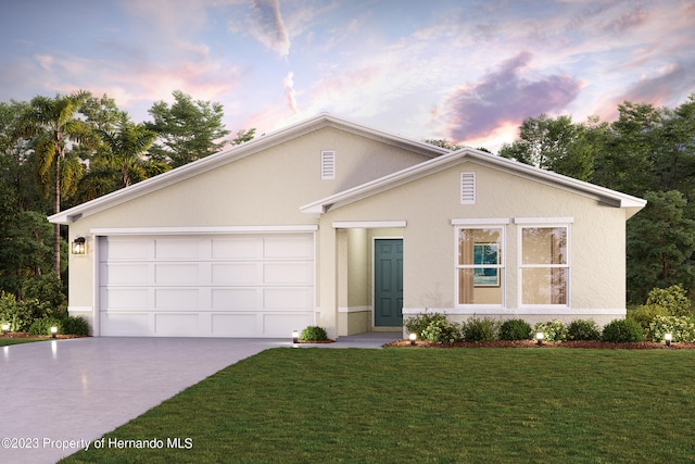 view of front of home with a garage and a yard