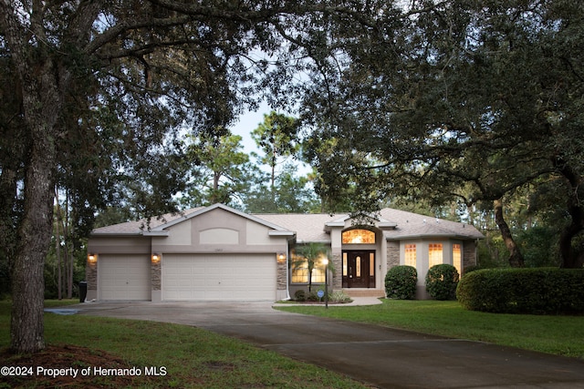 view of front facade featuring a garage, a front yard, and french doors