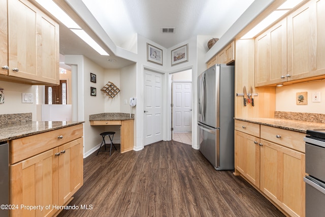 kitchen featuring stainless steel appliances, light brown cabinetry, light stone counters, and dark hardwood / wood-style flooring