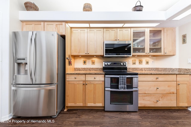 kitchen with dark wood-type flooring, light brown cabinets, appliances with stainless steel finishes, and light stone countertops