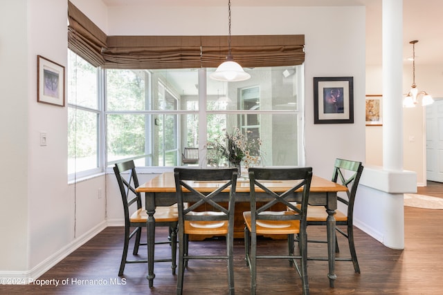 dining room with dark wood-type flooring and a chandelier