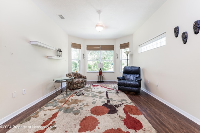 sitting room featuring dark wood-type flooring, ceiling fan, and plenty of natural light