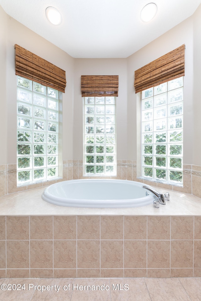 bathroom featuring tile patterned flooring and tiled tub