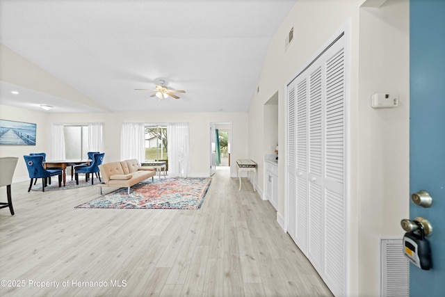 living room featuring ceiling fan, lofted ceiling, and light hardwood / wood-style floors