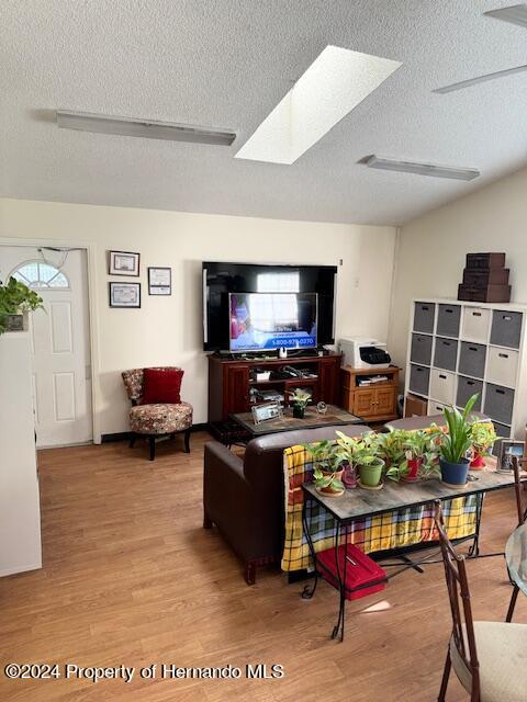 living room featuring light hardwood / wood-style flooring and a textured ceiling