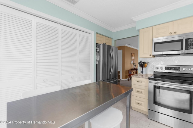 kitchen featuring ornamental molding, backsplash, appliances with stainless steel finishes, light tile patterned floors, and a kitchen breakfast bar