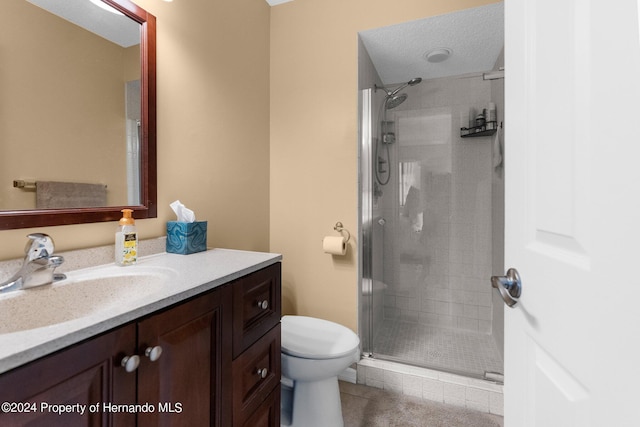 bathroom featuring toilet, vanity, a textured ceiling, and walk in shower