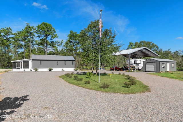 view of front of property featuring a garage, an outbuilding, and a carport