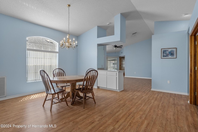 dining space featuring high vaulted ceiling, a textured ceiling, light hardwood / wood-style floors, and ceiling fan with notable chandelier