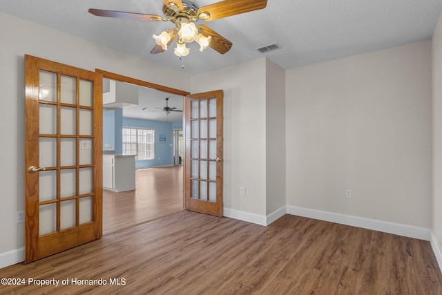 unfurnished room featuring hardwood / wood-style floors, ceiling fan, and a textured ceiling