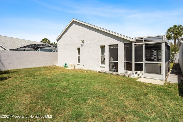 back of house featuring a sunroom and a yard