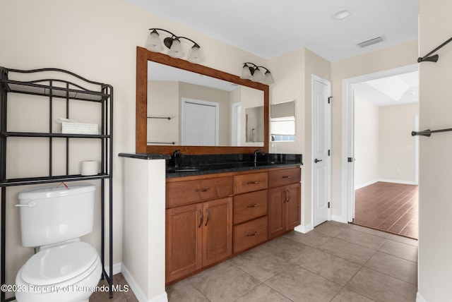 bathroom with wood-type flooring, toilet, and vanity