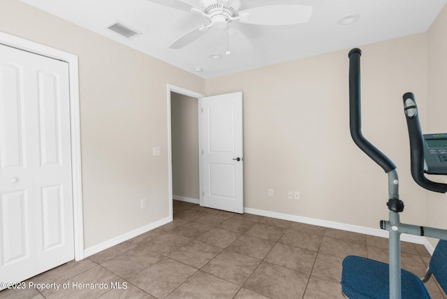 exercise area with light tile patterned flooring and ceiling fan