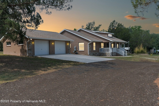 view of front facade featuring a garage, covered porch, and a lawn